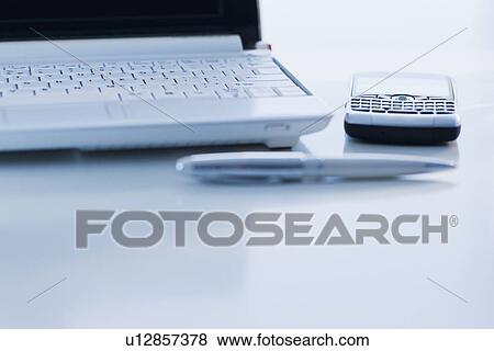 Cell phone and laptop on desk View Large Photo Image Stock Photo - Cell phone and laptop on desk. Fotosearch