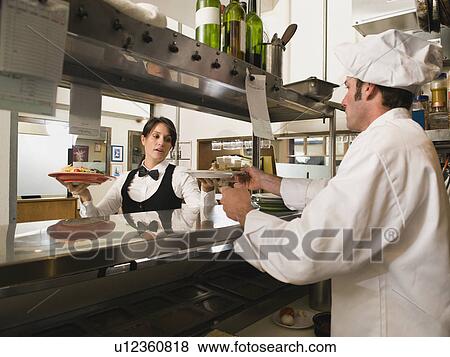 Stock Photo - Chef giving waitress plates of food. Fotosearch