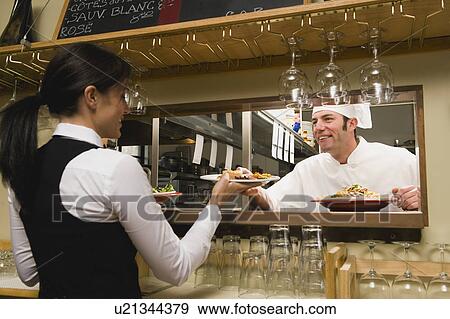 Chef giving waitress plates of food View Large Photo Image Stock Photo - Chef giving waitress plates of food. Fotosearch