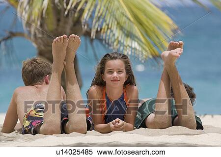 Stock Photography - Children relaxing on beach. Fotosearch
