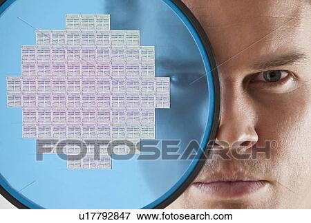 Close up of man looking through computer chip View Large Photo Image Stock Photo - Close up of man looking through computer chip. Fotosearch