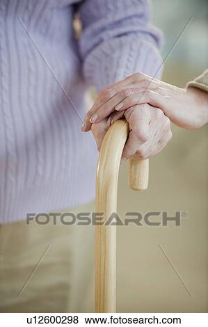 Stock Photo - Close up of senior woman holding cane. Fotosearch