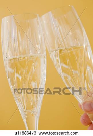Stock Image - Close up of toasting champagne glasses. Fotosearch