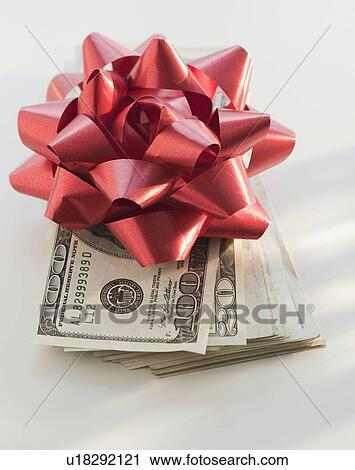 Stock Image - Coins and dollar bills in money clip. Fotosearch