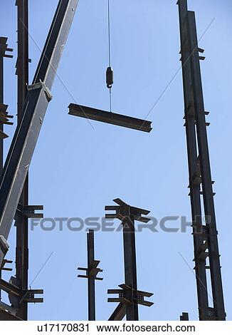 Stock Image - Crane moving beam at construction site. Fotosearch