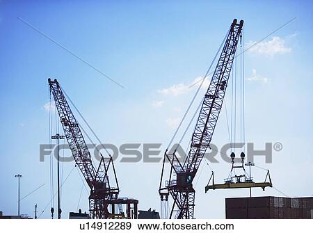Cranes moving shipping containers View Large Photo Image Stock Photo - Cranes moving shipping containers. Fotosearch