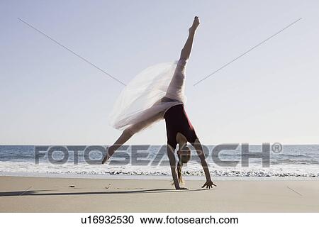 Stock Image - Dancer leaping on beach. Fotosearch
