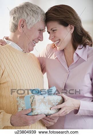 Daughter giving senior father gift View Large Photo Image Stock Photo - Daughter giving senior father gift. Fotosearch