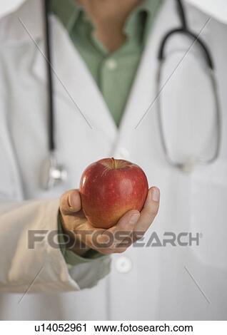 Doctor holding apple View Large Photo Image Stock Image - Doctor holding apple. Fotosearch