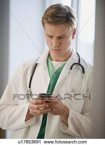 Stock Image - Doctor text messaging. Fotosearch