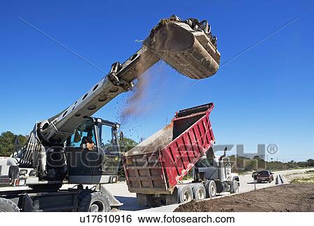 Stock Photograph - Dump truck and loader on construction site. Fotosearch