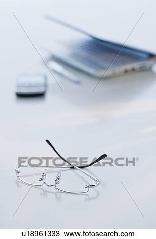 Stock Image - Eyeglasses and laptop on desk. Fotosearch