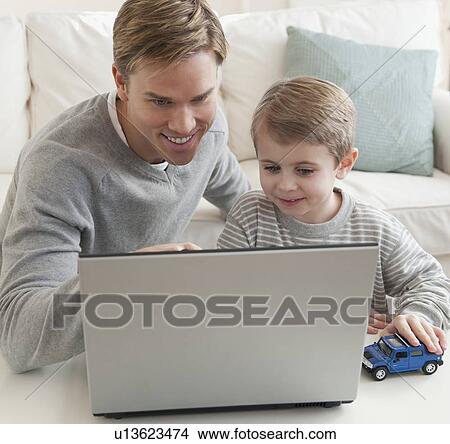 Father and son looking at laptop View Large Photo Image Picture - Father and son looking at laptop. Fotosearch