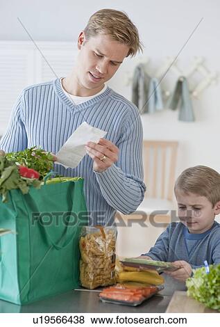 Father and son unpacking groceries View Large Photo Image Stock Photo - Father and son unpacking groceries. Fotosearch