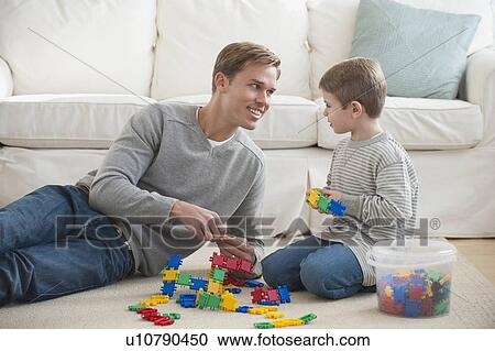 Father playing with son in livingroom View Large Photo Image Stock Image - Father playing with son in livingroom. Fotosearch
