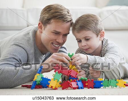 Father playing with son in livingroom View Large Photo Image Stock Image - Father playing with son in livingroom. Fotosearch