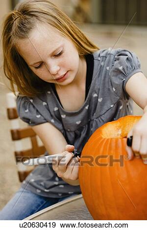 Girl drawing on pumpkin View Large Photo Image Stock Photo - Girl drawing on pumpkin. Fotosearch