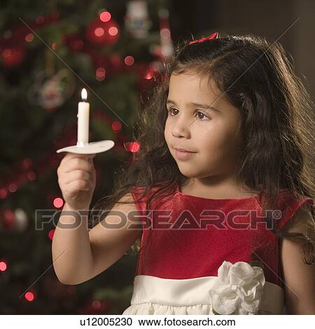 Stock Image - Girl holding Christmas candle. Fotosearch