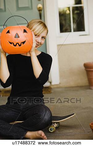 Girl holding plastic jack-o-lantern bucket View Large Photo Image Stock Image - Girl holding plastic jack-o-lantern bucket. Fotosearch