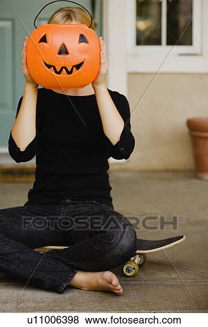 Girl holding plastic jack-o-lantern bucket View Large Photo Image Stock Photo - Girl holding plastic jack-o-lantern bucket. Fotosearch