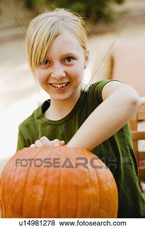 Girl scooping out pumpkin View Large Photo Image Stock Photo - Girl scooping out pumpkin. Fotosearch