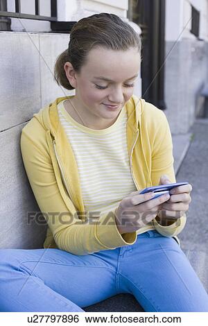 Girl text messaging on steps View Large Photo Image Stock Photograph - Girl text messaging on steps. Fotosearch