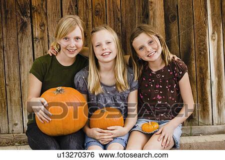 Girls holding pumpkins View Large Photo Image Stock Photograph - Girls holding pumpkins. Fotosearch