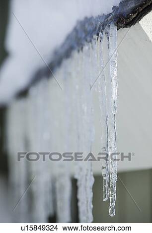 Picture - Icicles hanging from roof eaves. Fotosearch