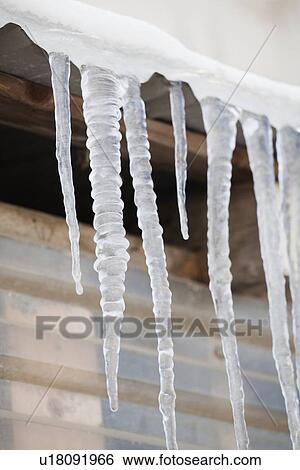 Icicles hanging from roof eaves View Large Photo Image Stock Photograph - Icicles hanging from roof eaves. Fotosearch