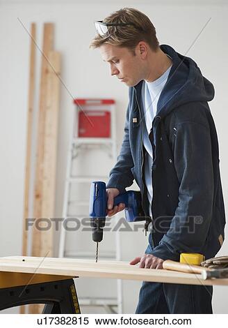 Man drilling on board View Large Photo Image Stock Photography - Man drilling on board. Fotosearch