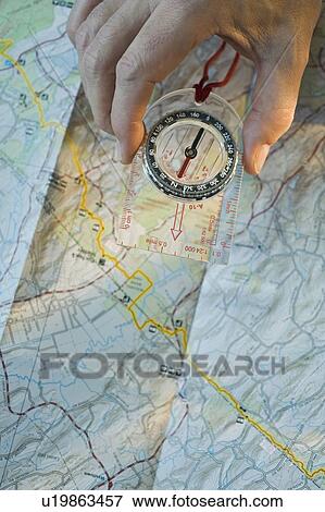 Stock Photo - Man holding compass over map. Fotosearch