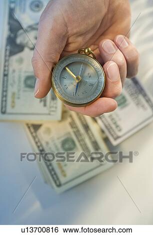 Man holding compass over money View Large Photo Image Stock Photograph - Man holding compass over money. Fotosearch