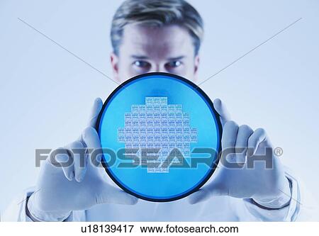 Stock Photo - Man holding computer chip. Fotosearch