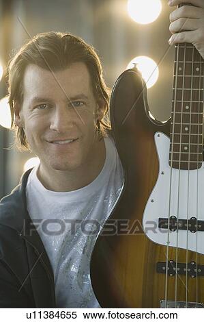 Man holding electric guitar View Large Photo Image Stock Photography - Man holding electric guitar. Fotosearch