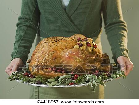 Man holding Thanksgiving turkey on decorated platter View Large Photo Image Stock Photo - Man holding Thanksgiving turkey on decorated platter. Fotosearch