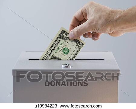 Man placing money in donation box View Large Photo Image Stock Image - Man placing money in donation box. Fotosearch