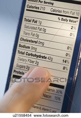 Picture - Man reading nutrition information. Fotosearch