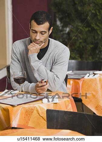 Man text messaging in restaurant View Large Photo Image Stock Photo - Man text messaging in restaurant. Fotosearch