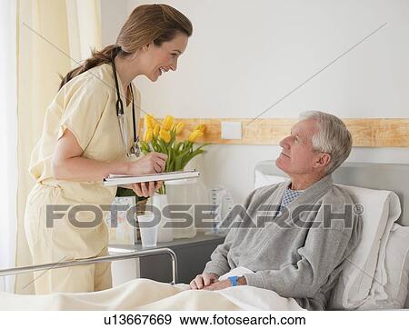 Nurse caring for senior man in hospital View Large Photo Image Stock Photo - Nurse caring for senior man in hospital. Fotosearch
