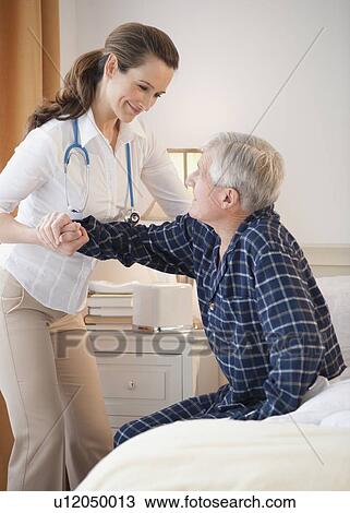 Nurse helping senior man out of man View Large Photo Image Stock Image - Nurse helping senior man out of man. Fotosearch