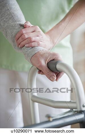 Nurse helping senior woman in walker View Large Photo Image Stock Image - Nurse helping senior woman in walker. Fotosearch