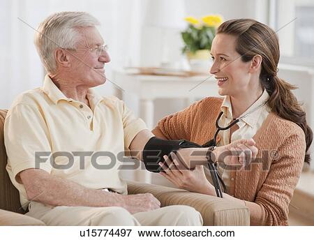 Stock Photo - Nurse taking senior man’s blood pressure. Fotosearch