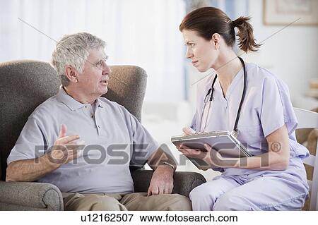 Stock Photo - Nurse talking to senior man. Fotosearch