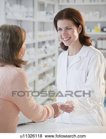 Pharmacist helping senior woman with prescription View Large Photo Image Stock Photo - Pharmacist helping senior woman with prescription. Fotosearch