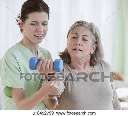 Stock Photo - Physical therapist helping senior woman. Fotosearch