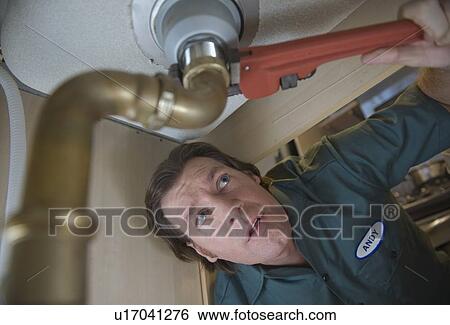 Plumber repairing sink View Large Photo Image Stock Photograph - Plumber repairing sink. Fotosearch