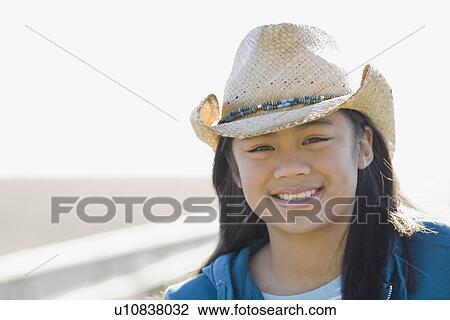 Stock Image - Portrait of teenage girl wearing cowboy hat. Fotosearch