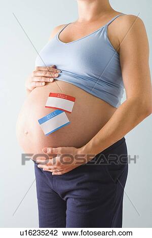 Pregnant woman with name tags on belly View Large Photo Image Stock Image - Pregnant woman with name tags on belly. Fotosearch