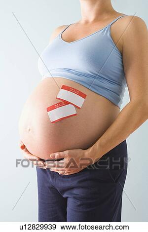 Pregnant woman with name tags on belly View Large Photo Image Stock Photo - Pregnant woman with name tags on belly. Fotosearch