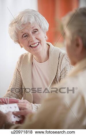 Stock Photo - Senior adults playing cards. Fotosearch